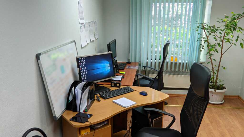 Типичный офис небольшого заведения: офисный стол, два стула, виднеется стул для персонала.